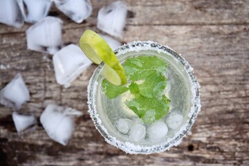 Making a margarita cocktail lime salt and mint leaves