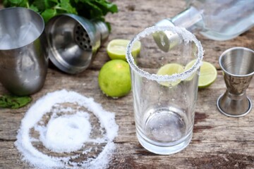 Making a margarita cocktail lime salt and mint leaves