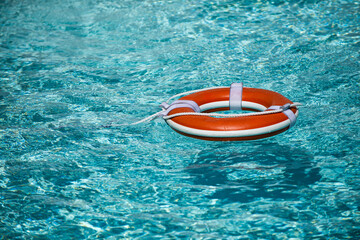 Life buoy for safety at pool in water. Safety equipment, rescue buoy floating to rescue people from...