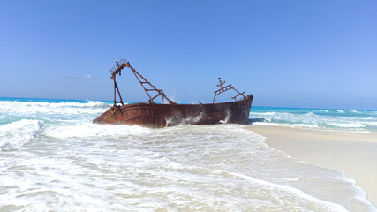 A Picture of a boat on the white sand of Alex beach 
 .shipwreck on the beach