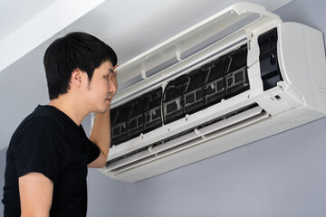 man open the air conditioner indoor at home