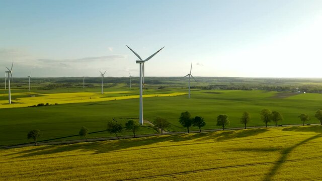 Wind Turbines cover the landscape of Lebcz Poland, Agricultural farming village - Aerial drone footage. 