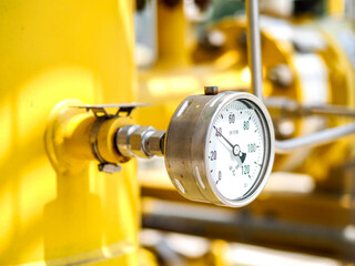 Temperature gauge for measuring instrument close up in industry zone at power plant.