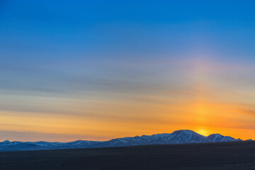 Beautiful sunset in mountains, in Kosh-Agach, Altai Republic, Russia. Bright sun and blue sky