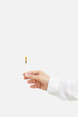 Female hand holds lit match. Wooden matchstick with fire. Fire Hazard concept.