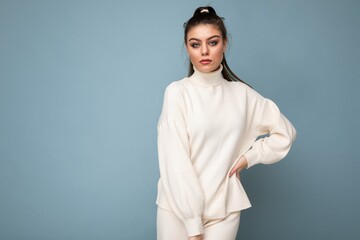 Young beautiful self-confident stylish brunette woman wearing casual white sweater poising isolated...