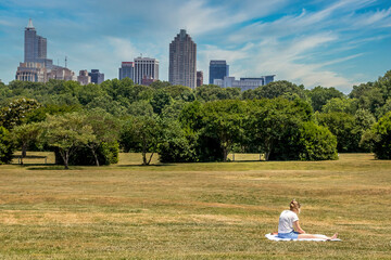 Young lady enjoying the park with views of the Raleigh skyline