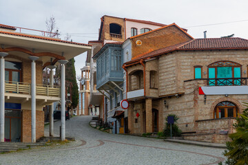 Fototapeta premium Traditional old houses with carved balconies on narrow winding streets in small Georgian town of Sighnaghi in springtime
