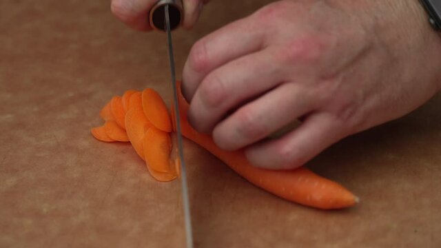 Thinly Sliced Carrots On A Wooden Board. - Close Up Shot