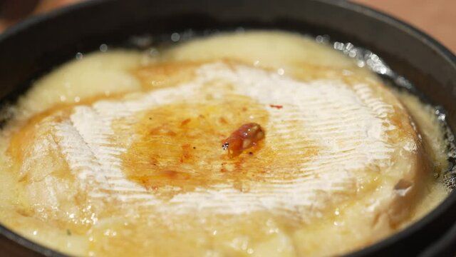 Placing Cooked Tomatoes On Top Of Provoleta. close up