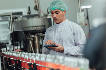 workers inspecting production line at drinks production factory. workingConcept