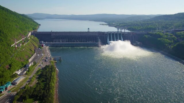Hydroelectric dam on the river, water discharge from the reservoir,  aerial video footage