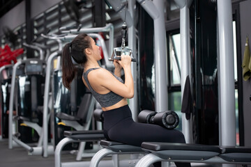 Fototapeta na wymiar Asian woman workout Close Grip Lat Pull Down in Fitness gym