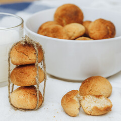 Sweet homemade cookies in bowl and glass of milk on white background