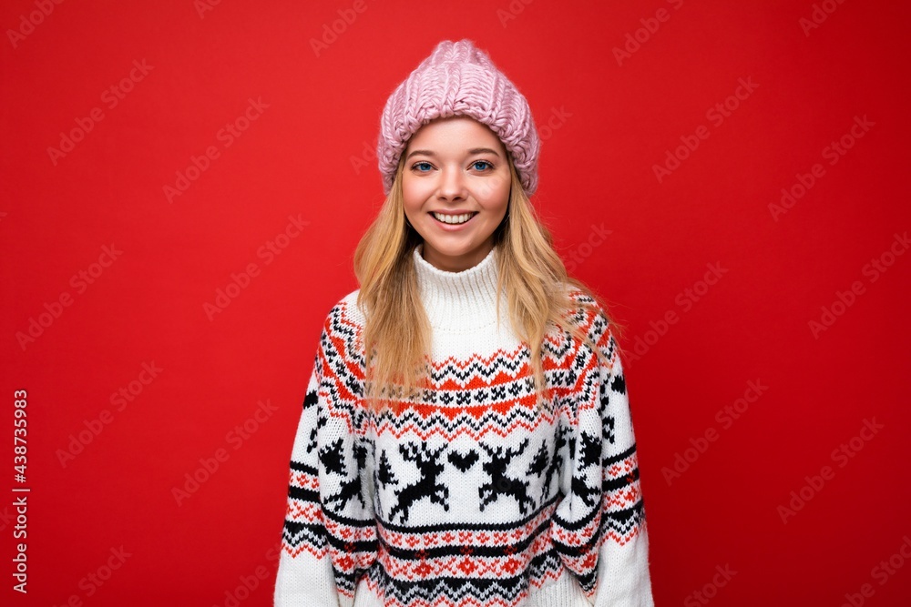 Wall mural attractive smiling happy young blonde woman standing isolated over colorful background wall wearing 