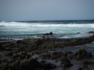 Volcanic coast of the Atlantic Ocean. Waves crash against black rocks. Tenerife, Canary Islands 