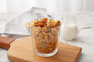 Glass with tasty granola on table