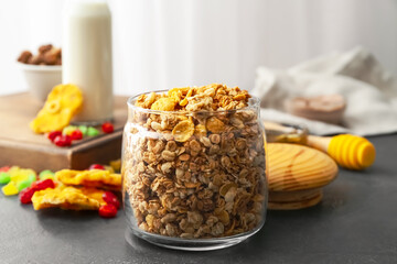 Glass jar with tasty granola on table