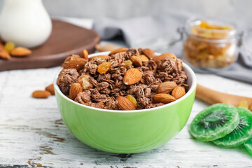 Bowl with tasty granola on white wooden background