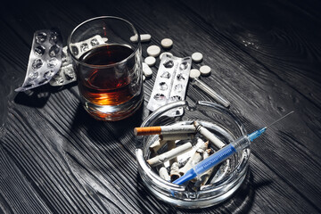 Alcohol, drugs and cigarettes on table. Concept of addiction