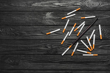 Many cigarettes on wooden background. Concept of addiction