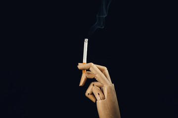 Wooden hand with cigarette on dark background. Concept of addiction