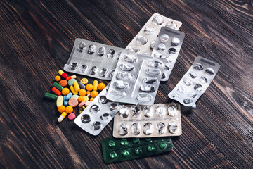 Many different pills on wooden background