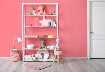 Shelf with toys and decor near color wall