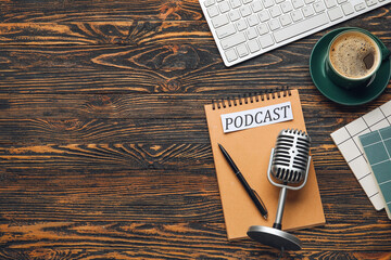 Retro microphone, computer keyboard, paper with word PODCAST and cup of coffee on wooden background