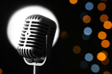 Fototapeta na wymiar Retro microphone against defocused lights, closeup