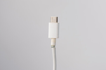 Torn cord for charging a mobile phone type si on a white background. Copy space.