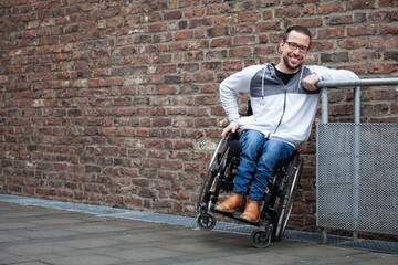 man in wheelchair leaning on a railing