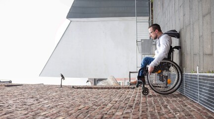 man in wheelchair rolling up a wall