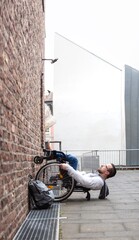 man in wheelchair rolling up a wall