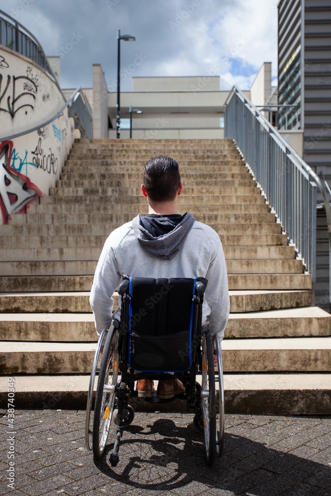 Poster man in wheelchair looking at stairs