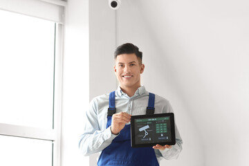 Worker with smart home security system control panel in room