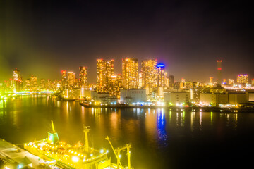 東京湾岸の夜景、停泊する船と対岸のビル群。