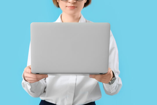 Female programmer with laptop on color background