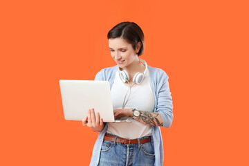 Female programmer using laptop on color background