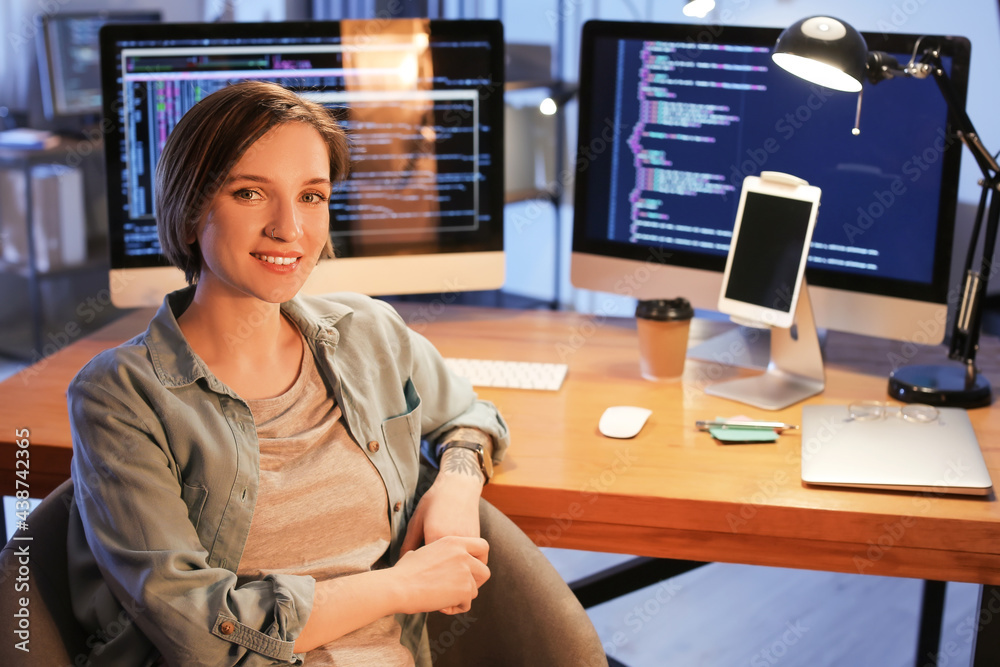 Wall mural female programmer working in office at night