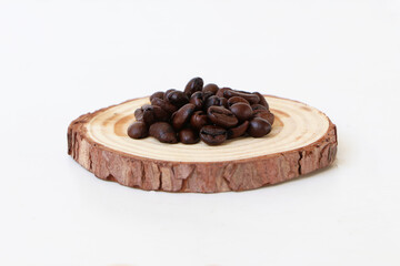 focus coffee Beans pile on a small brown wooden cutting board on white background area for copy space.