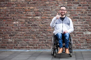 Fototapeta na wymiar man in wheelchair giving thumbs up