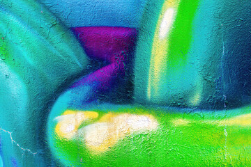 A fragment of colorful graffiti painted on a wall. Abstract urban background.