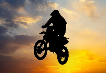 Fototapeta na wymiar Silhouette of a man on a motorcycle against the background of a golden