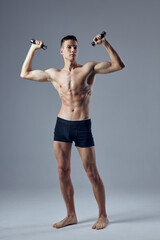 Fototapeta premium bodybuilder with dumbbells in hands pumped up body workout exercise isolated background
