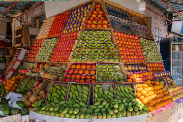 appetizing showcase of the fruit store with many boxes of mango, oranges, pomegranates, lemons