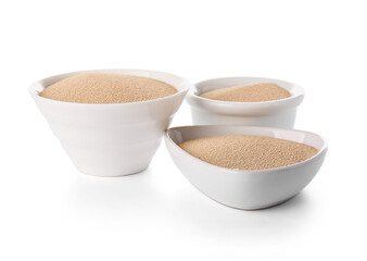 Bowls with active dry yeast on white background