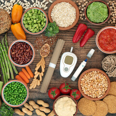 Fototapeta na wymiar Glucometer & lancing device with vegan food for diabetics below 55 on the GI index. High in antioxidants, anthocyanins, vitamins, minerals, protein, fibre, omega 3 & smart carbs. Flat lay on wood.