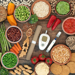 Glucometer & lancing device with vegan food for diabetics below 55 on the GI index. High in antioxidants, anthocyanins, vitamins, minerals, protein, fibre, omega 3 & smart carbs. Flat lay on wood.