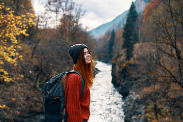 cheerful woman Tourist of all the law admires the nature of the mountain river